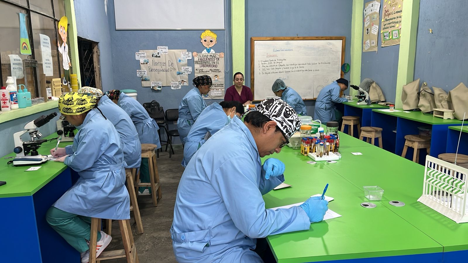 Estudiantes de LaboClid con bata haciendo prácticas en el laboratorio