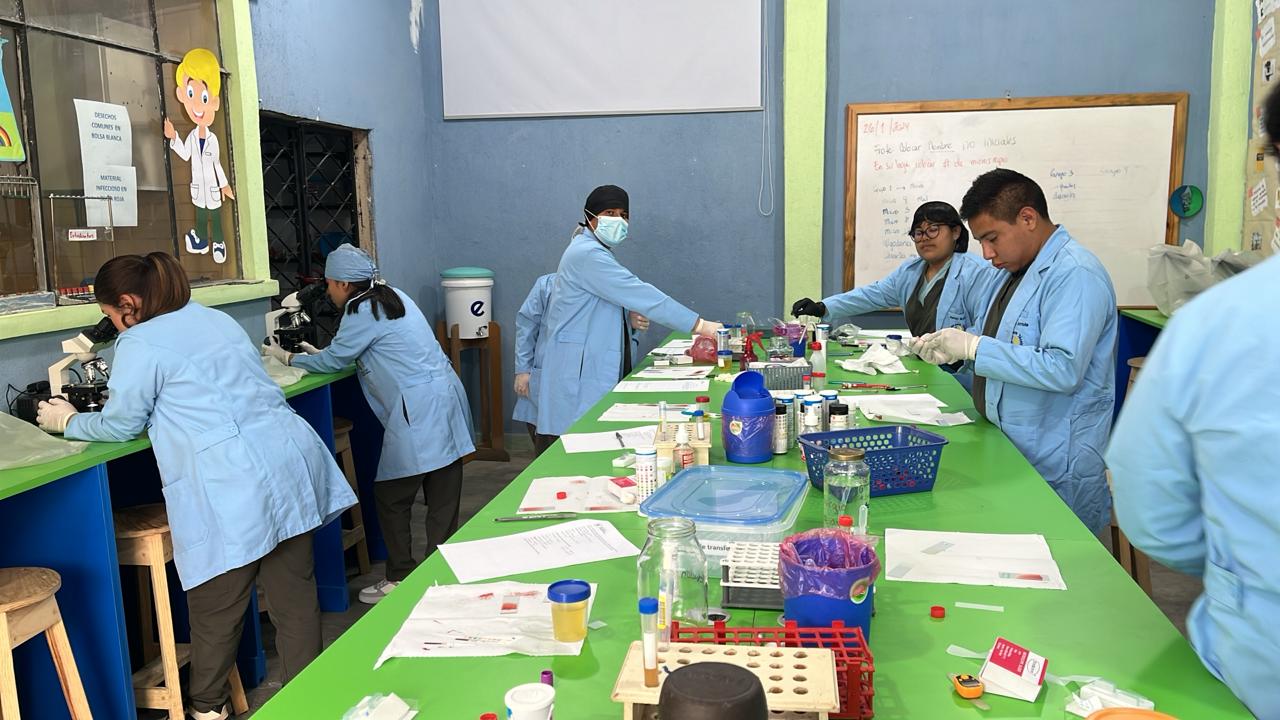 Estudiantes de LaboClid con bata haciendo prácticas en el laboratorio